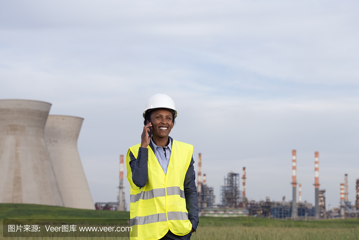 在化工廠打電話的女商人。